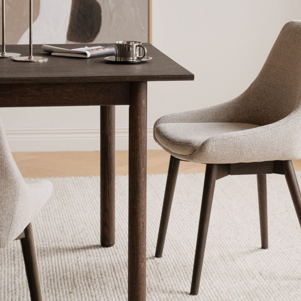 Rowico Denley spisebordsstol i lys beige stof og brunlakeret eg